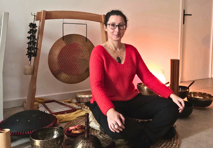 Alexandra Hazan en tailleur devant son gong.